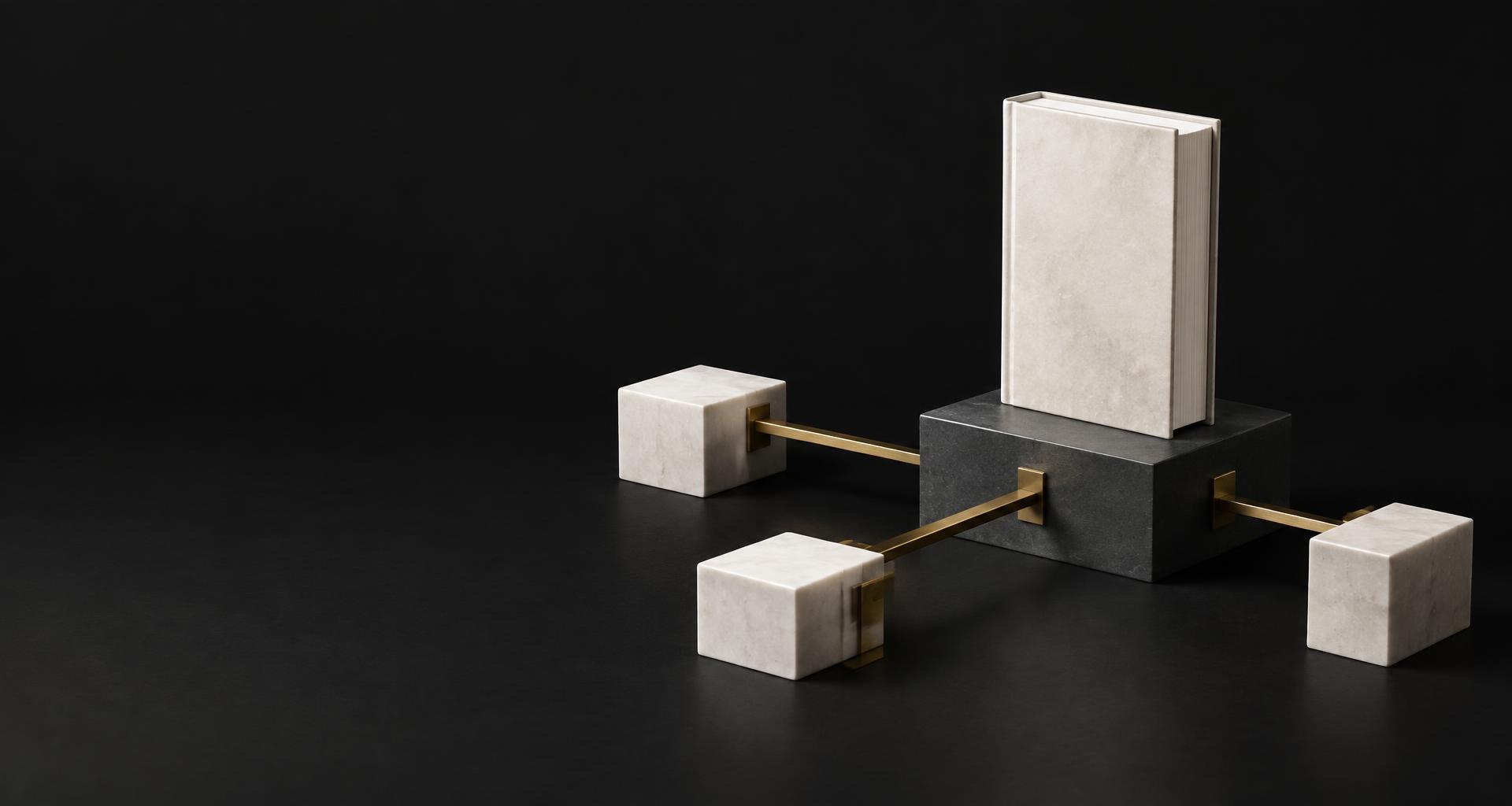 A book connected to direct distribution pathways in a sculptural brass and stone network